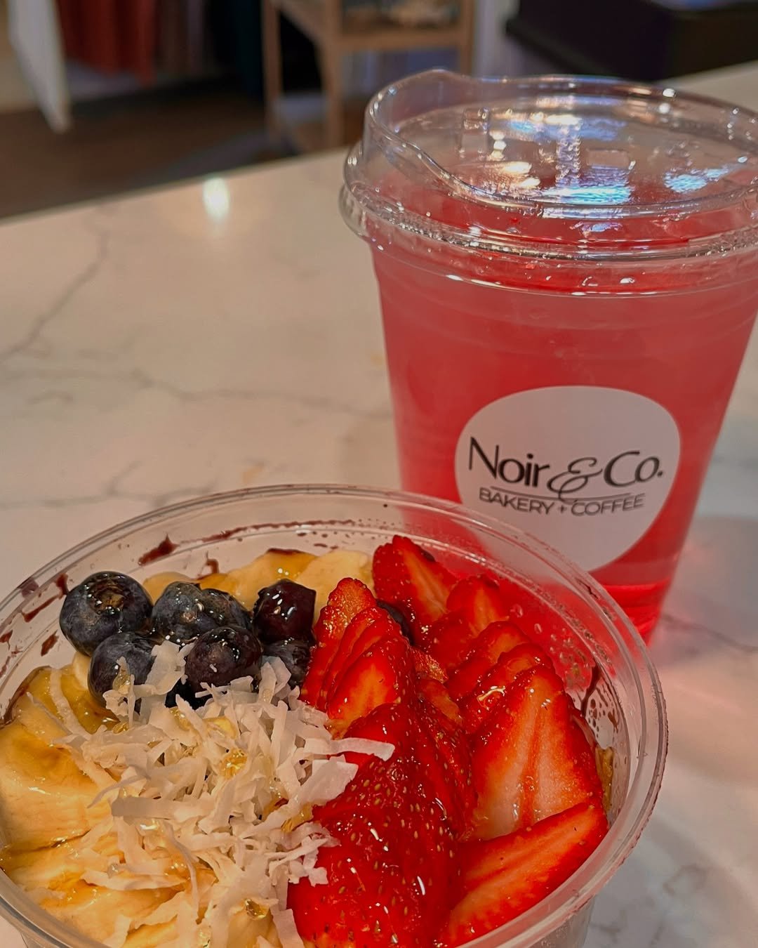 Acai bowl with fresh berries and a strawberry refresher at Noir Bakery & Coffee Co.