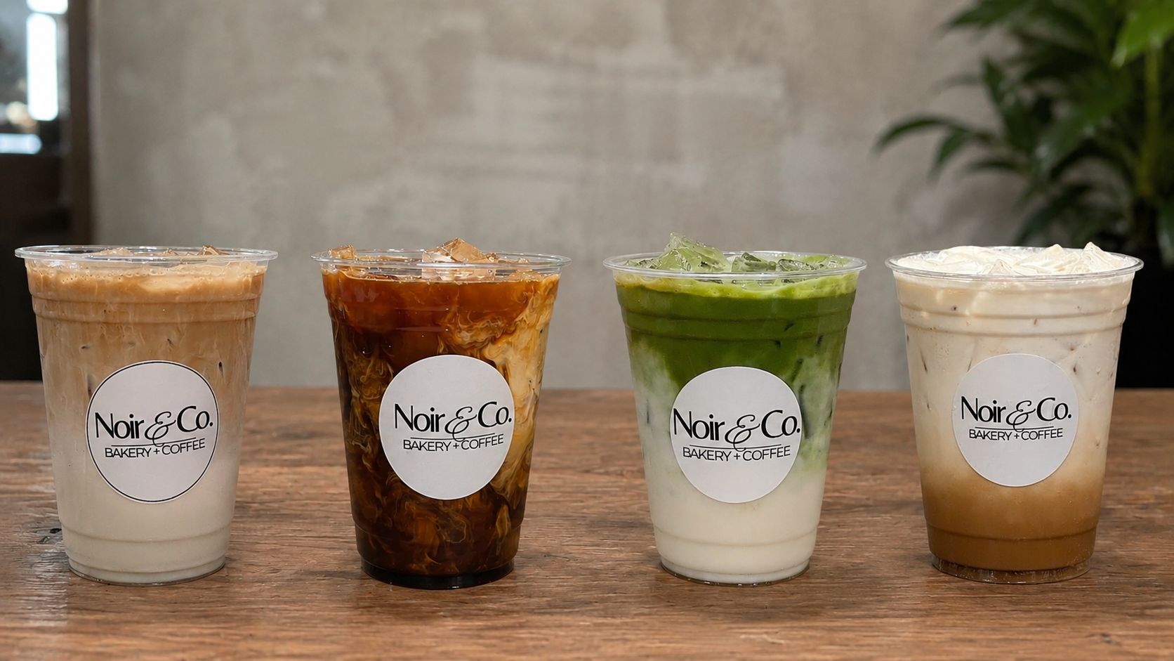 A lineup of iced lattes, cold brew, and a matcha latte from Noir Bakery & Coffee Co.
